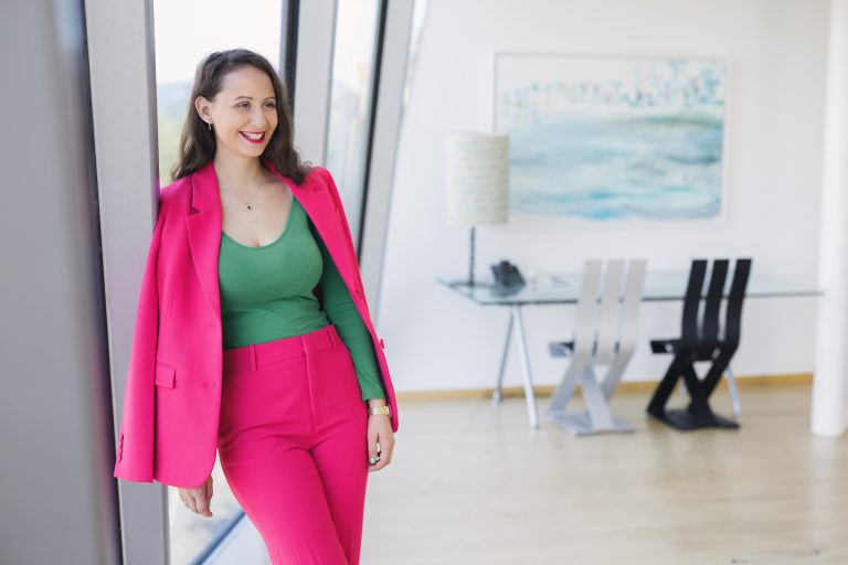 Sara Obereder an der Wand lehnend als unabhängige Finanzberaterin